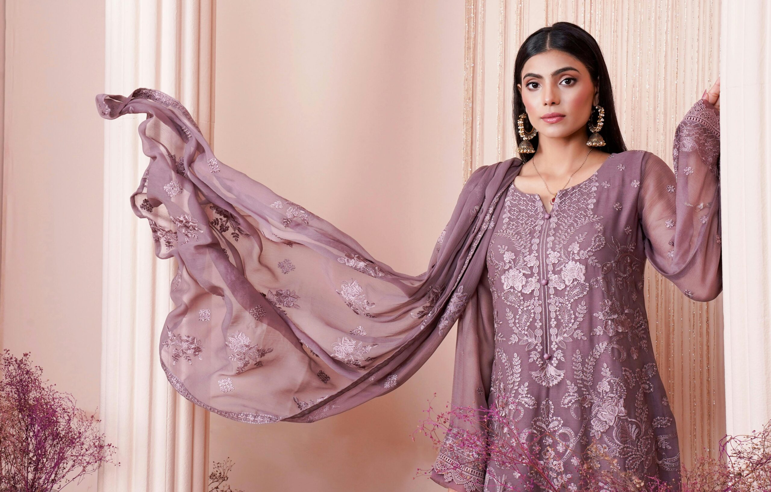 Model in embroidered dress posing in a Lahore studio, showcasing traditional Pakistani fashion with elegance.